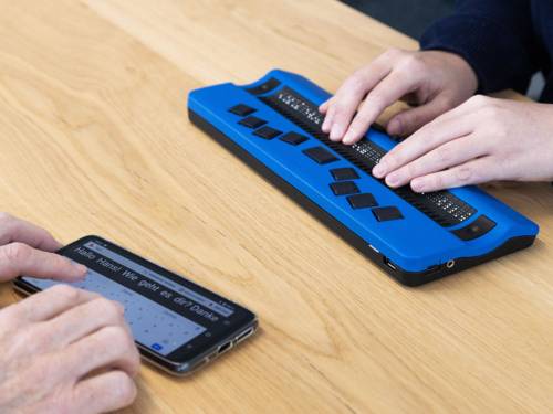 Das Tabli ist ein technisches Hilfsmittel und ist nicht größer als ein Smartphone. Es wird mit einer Braillezeile bedient und ermöglicht taubblinden oder hörsehbehinderten Menschen einen Dialog in Echtzeit.